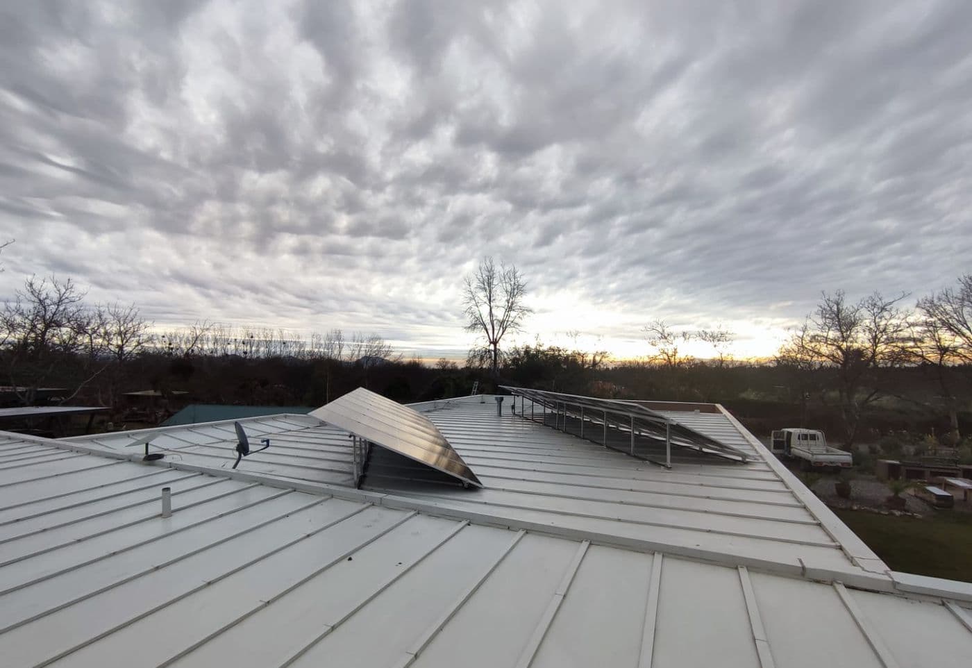 Paneles solares sobre un techo metálico bajo un cielo cubierto de invierno